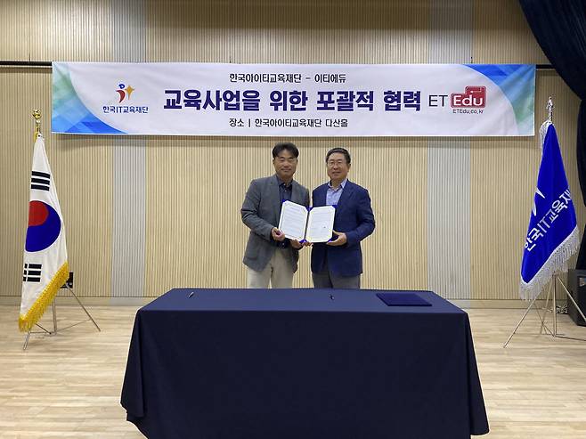 신혜권 이티에듀 대표(왼쪽)와 김명용 한국IT교육재단 이사장이 교육사업을 위한 포괄적 협력을 체결하고 협약서를 들어 보이고 있다.
