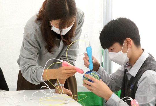 제8회 청소년 나Be 한마당이 12일 대전 유성구 유림공원에서 열려 진로직업 체험 박람회를 찾은 학생들이 3D펜으로 풍선램프를 만들고 있다.