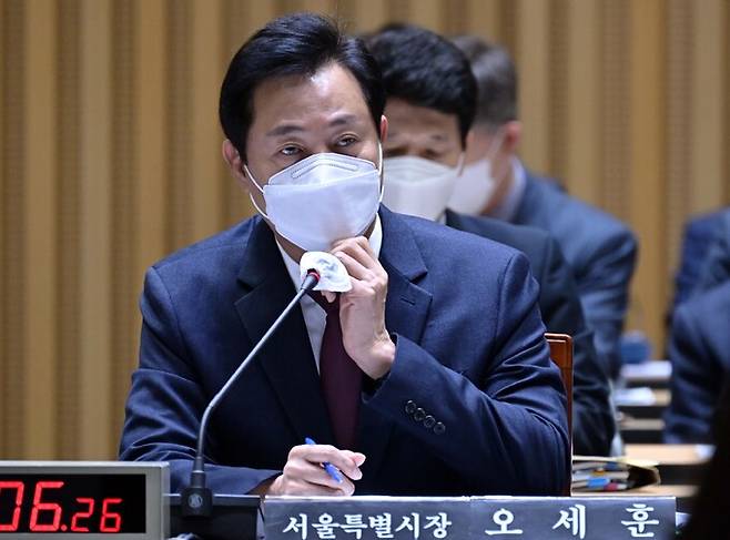 오세훈 서울시장이 12일 서울 중구 서울시청 대회의실에서 열린 국회 행정안전위원회 서울시에 대한 국정감사에서 마스크를 고쳐쓰고 있다. 뉴시스