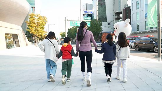 CJ나눔재단 ‘꿈키움 원더워크’에 참여한 지역아동센터 아동들이 선생님과 함께 서울 장충단로를 걸으며 야외활동을 하고 있다.