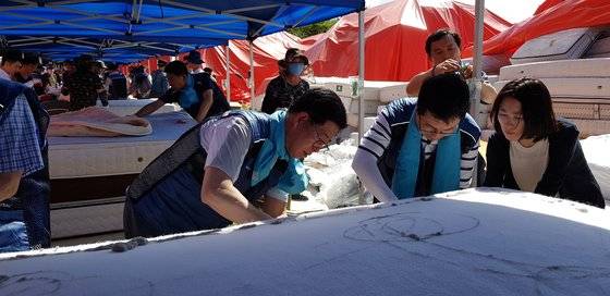 2018년 7월 31일 양승조 전 충님지사(왼쪽)가 천안시 직산읍 대진침대에서 도청 공무원들과 함께 라돈침대 매트리스를 해체하고 있다. 신진호 기자