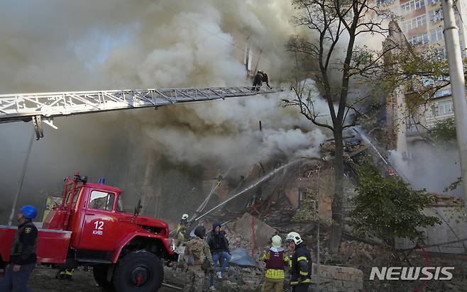 [키이우=AP/뉴시스] 17일(현지시간) 우크라이나 키이우에서 소방관들이 자폭 드론 공격을 받은 건물 화재를 진압하고 있다. 2022.10.17.