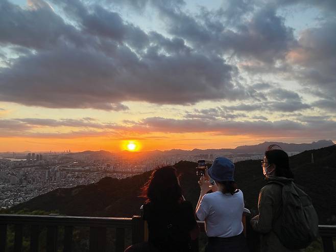 남산 하늘을 배경으로 펼쳐지는 일몰의 아름다움을 즐기고 있다.