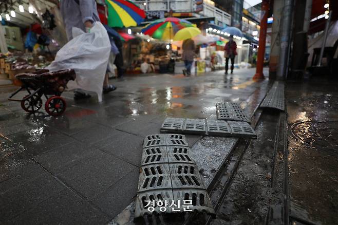 지난달 5일  서울 동작구 남성사계시장에서 한 관리인이 빗물받이 덮개를 점검하고 있다. /한수빈 기자