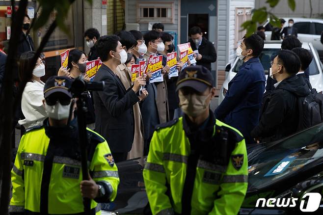 더불어민주당 의원들이 19일 오후 압수수색 중인 서울 여의도 더불어민주당사 앞에서 항의 손 피켓을 들고 있다. 서울중앙지검은 이날 대장동, 위례신도시 개발사업 특혜 의혹 사건과 관련해 민주당사 내 김용 민주연구원 부원장의 사무실 압수수색을 시도 했다. 2022.10.19/뉴스1 ⓒ News1 이재명 기자