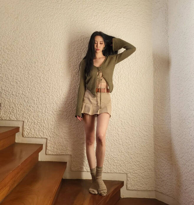 Sunmi in the public photo poses on the wooden stairs.