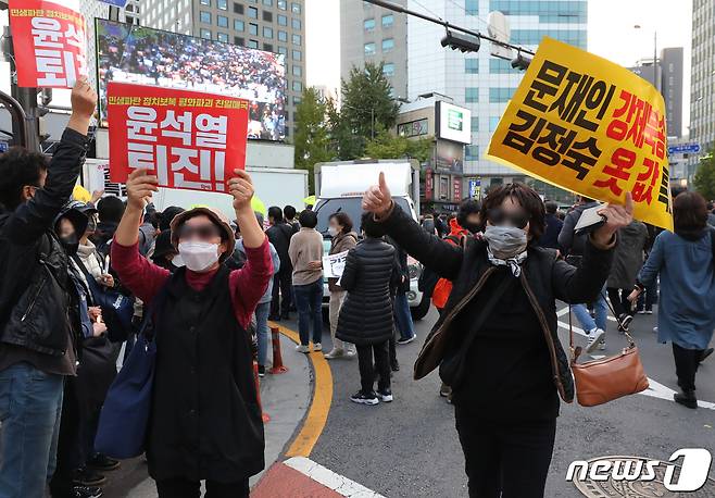 22일 서울 중구 세종대로에서 자유통일당 등 보수단체(오른쪽)와 촛불승리전환행동 등 진보단체 집회 참석자들이 손 피켓을 들고 있다. ⓒ News1 송원영 기자