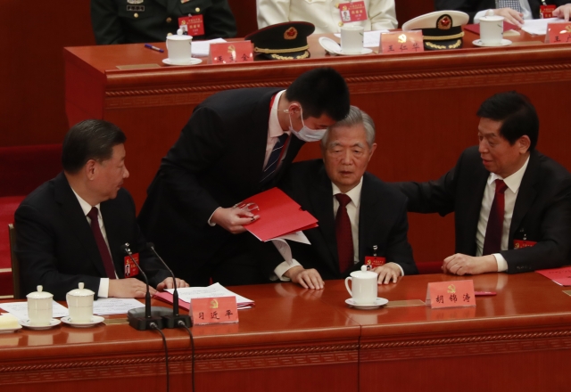 후진타오(오른쪽 두 번째) 전 중국 주석이 지난 22일 수도 베이징 인민대회당에서 열린 제20차 공산당 전국대표대회 폐막식에서 수행원의 부축을 받으며 자리에서 일어나고 있다. 연합뉴스