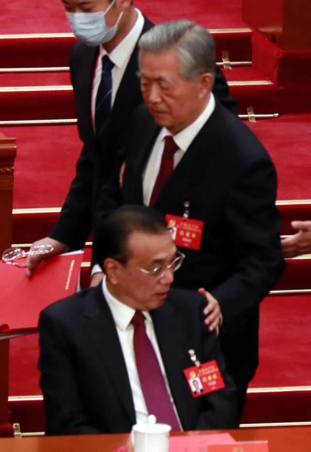 후진타오 전 중국 주석이 지난 22일 수도 베이징 인민대회당에서 열린 제20차 공산당 전국대표대회 폐막식 도중 퇴장하면서 리커창(앞) 총리의 어깨를 다독이고 있다. 연합뉴스