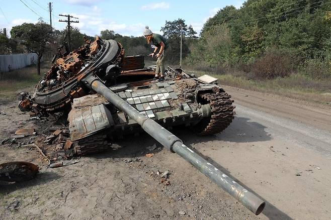 우크라이나 현지 주민이 버려진 러시아군 T-72 전차를 살펴보고 있다. AFP연합뉴스