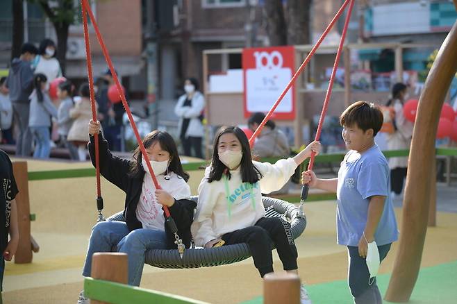 지난 11일 재단장한 용마어린이공원 놀이터에서 아이들이 다인승 그네를 타고 놀고 있다. 세이브더칠드런 제공