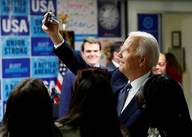 조 바이든 미 대통령이 24일(현지시간) 워싱턴 민주당 전국위원회(DNC) 본부에서 지지자들과 휴대폰으로 셀프 사진을 찍고 있다. [로이터]