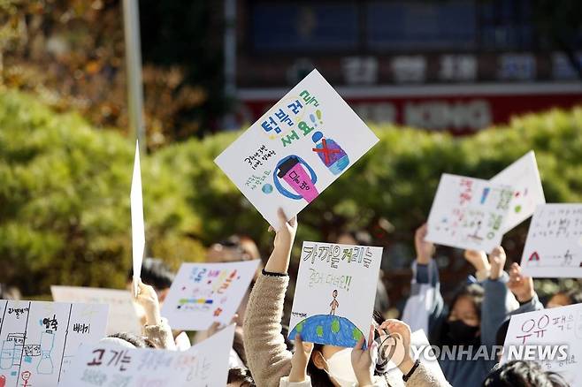 지난 19일 오전 '기후환경 캠페인'에 참가한 광주 북구 효동초등학교 3학년 학생들이 환경 보호 손팻말을 들고 북구청 광장까지 길거리 캠페인을 펼치고 있다. [광주 북구 제공. 재판매 및 DB 금지]