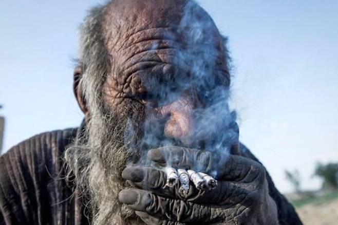 아모 하지가 생전 여러 개피의 담배를 피우고 있는 모습. AFP=연합뉴스