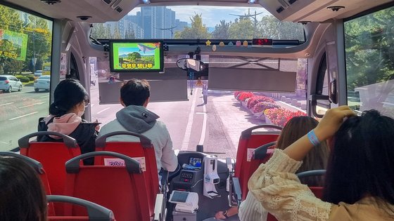 11월까지 창원시가 특별 운행하는 '우영우 팽나무 버스'의 실내 모습. 버스가 운행하는 동안 '우영우 팽나무' TV 방영 장면을 보여준다. 사진 창원시