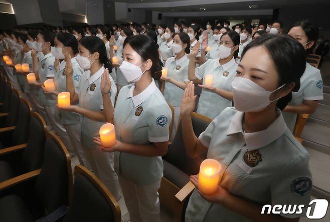 28일 오후 대구 영진전문대학교 도서관 시청각실에서 열린 '제36회 나이팅게일 선서식'에 참석한 간호학과 2학년생 133명이 촛불을 밝혀 들고 나이팅게일의 숭고한 정신을 이어받아 헌신적인 간호 활동을 펼칠 것을 선서하고 있다. 2022.10.28/뉴스1 ⓒ News1 공정식 기자