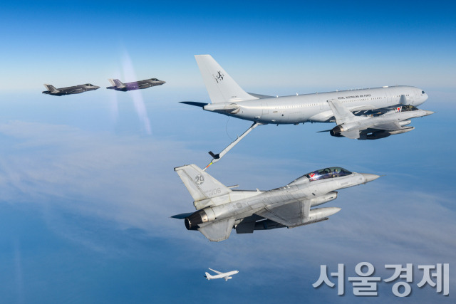 우리 공군의 KF-16 전투기 4대 및 다목적 공중급유수송기(KC-330) 1대가 지난 8월 24일(현지시간) 호주 상공에서 호주 공군의 F-35A 2대 공중급유기 KC-30A 1대와 연합 공중급유 훈련을 실시하고 있다 2대의 KF-16(맨 앞 오른쪽) 전투기 후방석 조종사가 양국 공군 간의 굳건한 협력관계를 표현하기 위해 태극기와 호주국기를 함께 들고 있다 그 아래로 한국 KC-330(맨 아래)과 호주 F-35A(가장 왼쪽) 2대가 비행 중이다. 사진제공=공군