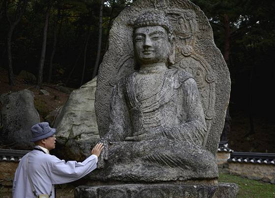자현스님이 경주 남산 보리사에 있는 석불을 만져보고 있다. [사진 자현스님]