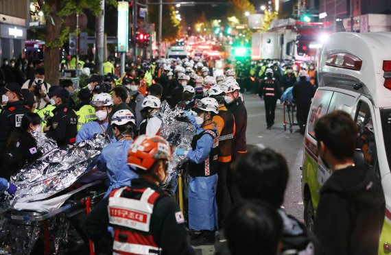 지난 29일 밤 서울 용산구 이태원 일대에서 대규모 압사사고가 발생해 30일 새벽 소방구급 대원들이 환자를 이송하고 있다. 뉴시스