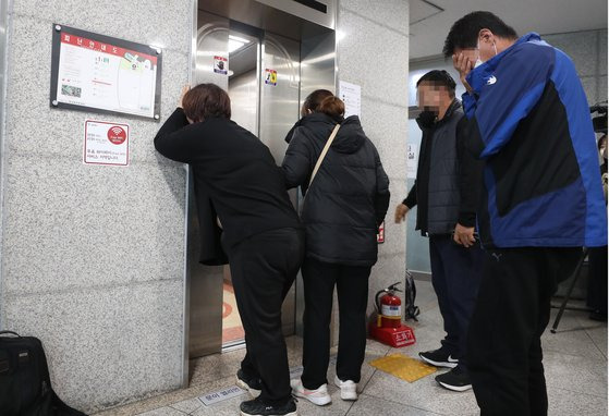 30일 오후 한남동 주민센터에 마련된 실종자 접수처 대기실 앞에서 가족들이 사망자 명단을 확인하고 오열하고 있다. 뉴시스