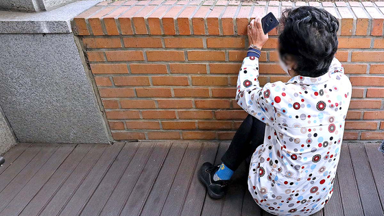 A woman collapses after receiving news about a family member outside Hannam-dong Community Service Center in Yongsan District, central Seoul, on Sunday. [NEWS1]