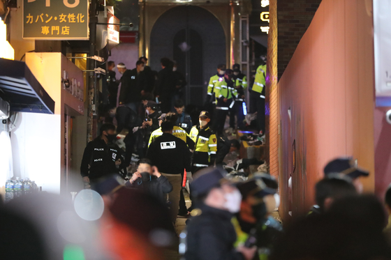 Police and firefighters inspect an alleyway near Hamilton Hotel in Itaewon, Yongsan District, where most of the casualties from a crowd crush that killed at least 153 people were found, in the early hours of Sunday. [NEWS1]