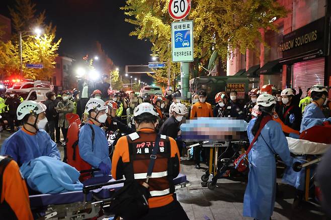 지난 29일 발생한 서울 용산구 이태원 핼러윈 인명사고 현장에서 사망자가 병원으로 후송되고 있다. [연합]