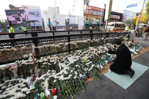 [서울=뉴시스] 조수정 기자 = 31일 오전 서울 용산구 이태원 압사 참사 현장 인근인 이태원역 1번출구 앞 희생자 추모공간에서 한 시민이 고인들을 애도하는 술을 올리고 있다. 2022.10.31. chocrystal@newsis.com <저작권자ⓒ 공감언론 뉴시스통신사. 무단전재-재배포 금지.> /사진=뉴시스화상