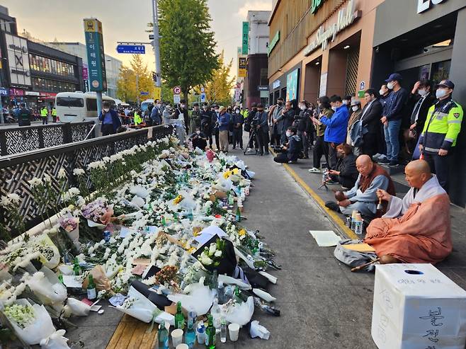 Buddhist monks chant a prayer near the site of a stampede in Seoul's Itaewon district on Monday that left at least 154, including 26 foreigners, killed during Halloween festivities two days ago. (Choi Jae-hee / The Korea Herald)