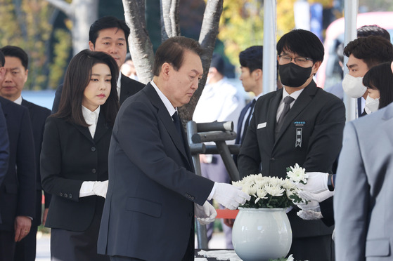 President Yoon Suk-yeol, center, and first lady Kim Keon-hee visit a mourning altar for the victims of the Halloween tragedy in Itaewon at Seoul Plaza in central Seoul on Monday morning. [YONHAP]