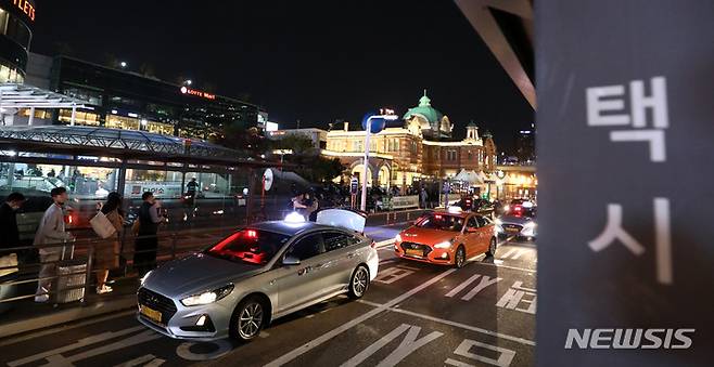 [서울=뉴시스] 이영환 기자 = 지난 26일 오후 서울 중구 서울역 택시승강장에서 승객들이 택시를 기다리고 있다. 이날 밤 10시부터 다음날 새벽 3시까지 야간에만 운행하는 서울 개인택시 심야운행조가 가동한다. 차량 끝번호로 5개조로 나누어 월요일에는 차량 끝 번호 1·6, 화요일엔 2·7, 수요일엔 3·8 등으로 조를 짜 밤 10시부터 새벽 3시까지 영업하는 방식이다. 이로 인해 쉬는 택시가 영업에 나서 택시난이 어느정도 해소될 것으로 예상된다.  2022.10.31. 20hwan@newsis.com