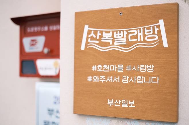 지난 5월9일 부산 산복도로 한복판, 부산진구 호천마을에 빨래방을 연 부산일보 김준용, 이상배 기자와 이재화, 김보경 PD는 지난달 31일을 끝으로 6개월간의 여정을 마무리했다. 사진은 산복빨래방 간판. /부산일보 제공