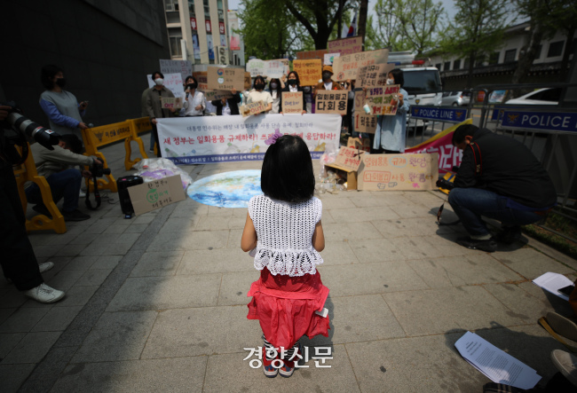 한 어린이가 지구의 날을 하루 앞둔 지난 21일 서울 종로구 대통령직 인수위 앞에서 열린 식품 접객업 매장 내 1회용품 규제의 완전한 시행을 촉구하는 기자회견을 바라보고 있다. / 권도현 기자