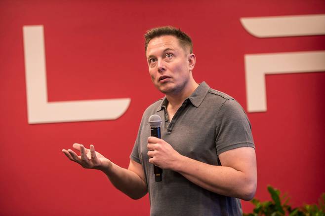 Elon Musk, chairman and chief executive officer of Tesla Motors, speaks during an event the company‘s headquarters in Palo Alto, California, U.S., on Wednesday, Oct. 14, 2015. Tesla Motors Inc. will begin rolling out the first version of its highly anticipated “autopilot” features to owners of its all-electric Model S sedan Thursday. Autopilot is a step toward the vision of autonomous or self-driving cars, and includes features like automatic lane changing and the ability of the Model S to parallel park for you. Photographer: David Paul Morris/Bloomberg *** Local Caption *** Elon Musk