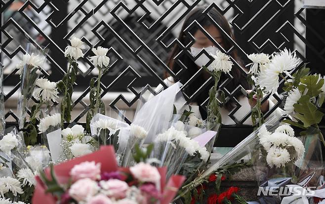 [서울=뉴시스] 정병혁 기자 = 1일 오전 서울 용산구 이태원역에 마련된 추모공간을 찾은 시민이 헌화하고 있다. 2022.11.01. jhope@newsis.com