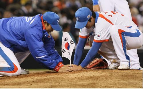 2009년 WBC에서 4강 진출에 성공한 뒤 마운드에 태극기를 꽂고 있는 봉중근과 이진영. 연합뉴스