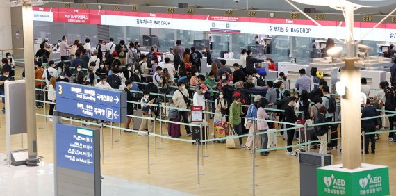 인천국제공항 1터미널 출국장에서 여행객들이 탑승 수속을 위해 기다리고 있다. 연합뉴스.