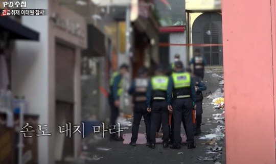 지난 29일 참사가 벌어진 서울 용산구 이태원동 현장에 제삿상을 차린 인근 상인 A 씨를 경찰이 제지하고 있다. [MBC PD수첩 방송 캡처]