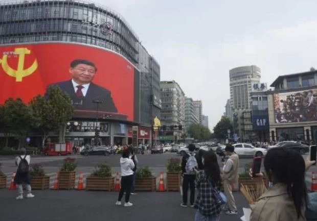 건물에 노출되는 시진핑 국가주석 영상을 찍고있는 청년들. 항저우=AP연합