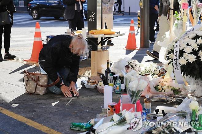 이태원 참사 희생자 추모하는 외국인 (서울=연합뉴스) 한종찬 기자 = 2일 서울 용산구 이태원역 1번 출구 앞 참사 추모 공간을 찾은 외국인이 추모하고 있다. 2022.11.2 saba@yna.co.kr