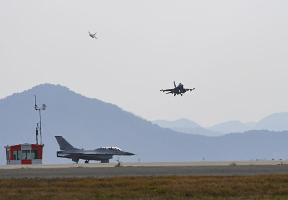 한미공군의 대규모 연합공중훈련 “비질런트 스톰(Vigilant Storm)" 훈련에 참가한 우리 공군 KF-16 전투기가 군산기지에서 이륙을 위해 활주로 진입을 기다리고 있는 가운데, 그 위로 미군 F-16 전투기가 착륙을 하고 있다. 사진=공군 제공