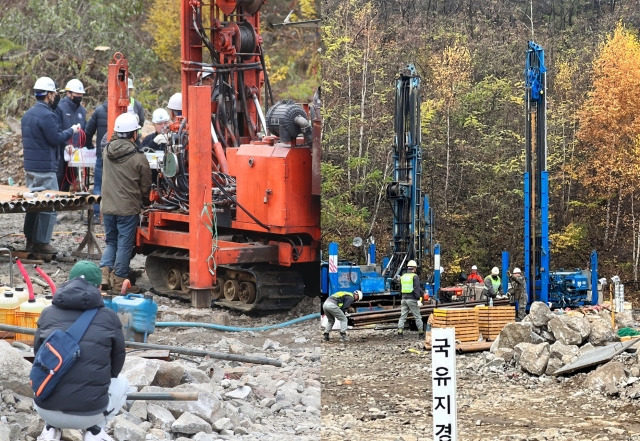 경북 봉화군 광산 매몰 사고 9일째인 3일 오전 고립된 작업자 2명의 생존 신호를 확인하기 위해 투입된 시추기 중 2대가 '구조 예상 지점'에 도달했다. 이날 오전 9시께 현장에서 구조 관계자들이 갱도 내부를 내시경과 마이크 장비 등을 활용해 고립된 작업자들과 대화를 시도하고 있다. 고립된 작업자 가족들이 뒤에서 지켜보고 있다. 연합뉴스