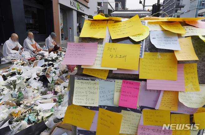 [서울=뉴시스] 고승민 기자 = 3일 서울 용산구 이태원역 1번 출구 앞에 마련된 '이태원 사고' 희생자 추모 공간에서 스님들이 희생자들을 추모하며 불경을 외고 있다. 2022.11.03. kkssmm99@newsis.com