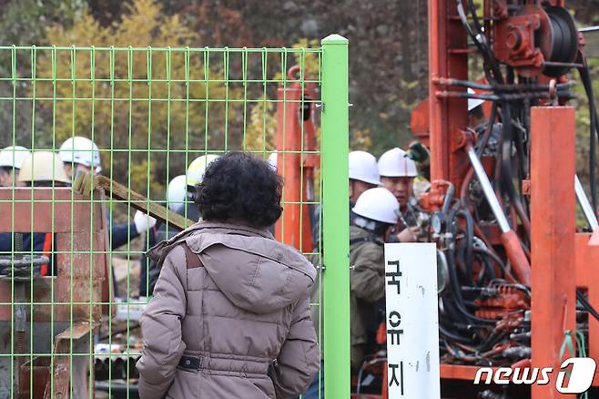 지난 3일 오전 경북 봉화군 아연광산 매몰 사고 현장에서 한국광해광업공단 등 구조반 관계자들이 천공기를 이용해 확보한 지하 170m 지점에 내시경을 넣어 고립 작업자들의 생존 여부를 확인하고 있다. 뒤편에서 가족들이 구조작업을 애타게 지켜보고 있다. 2022.11.3/뉴스1 ⓒ News1 공정식 기자