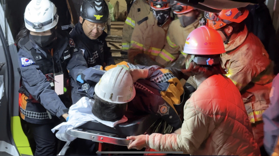 경북 봉화군 광산 매몰사고 열흘째인 4일 오후 11시쯤 구조팀들이 광부 2명을 구조해 안동병원으로 이송하고 있다. [사진 경북소방본부]