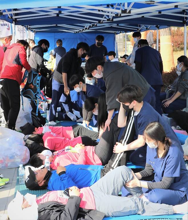 자원봉사자로 참가한 선문대 스포츠재활학과 학생들이 달리기를 마친 참가자들의 근육을 풀어주고 있다.