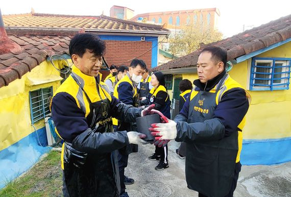 엄기민 쌍용차 사장(왼쪽)과 선목래 쌍용차 노조위원장이 연탄 봉사활동에 참여하고 있다. 쌍용차 제공