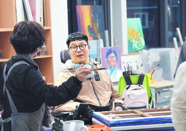 임경식 작가가 지난 6일 경기도 안양 소울음아트센터에서 동료 화가들과 전시회를 준비하고 있다. 임 작가는 매주 2회 이곳을 방문해 문주호 경희대 겸임교수에게 지도를 받는다.