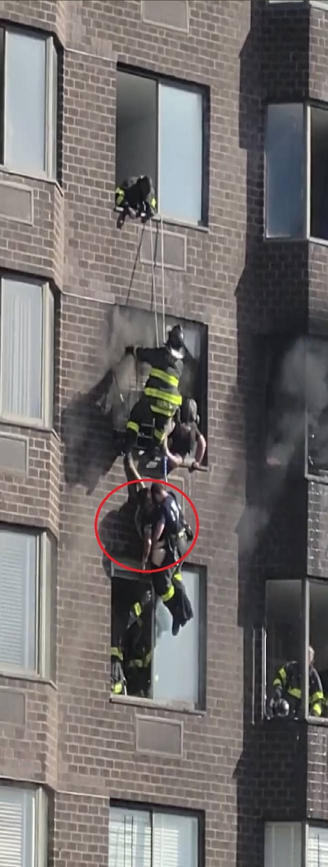 [서울=뉴시스] 미국 뉴욕에서 화재가 발생한 건물 20층에 매달려 있던 여성(벽 쪽에 팔 뻗고 있는 여성)이 밧줄로 구조됐다고 7일(현지 시간) 더 미러가 보도했다. <출처 : Patti Ryan 트위터 캡처> 2022.11.09. *재판매 및 DB 금지