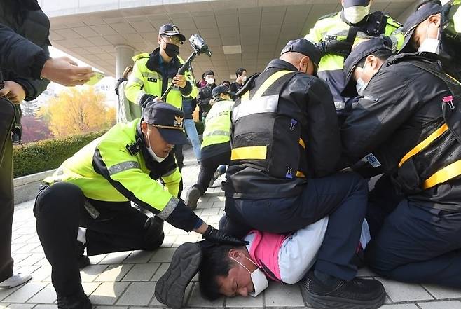 11월10일 오전 최진선 학교비정규직노동조합 경기지부장이 경기도교육청 남부청사 건물 앞에서 경찰들에게 체포되고 있다.전국학교비정규직노동조합 경기지부 제공